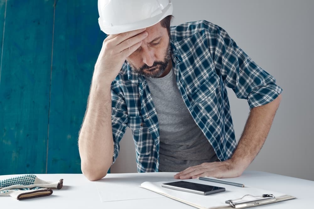 Man calculating construction project going over budget